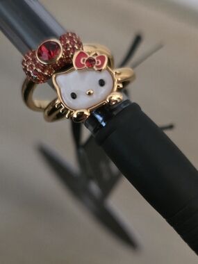 Hello Kitty x kate spade gold and red charm rings.